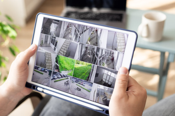 在室内数字平板电脑上监控现代闭路电视摄像头的人图片下载