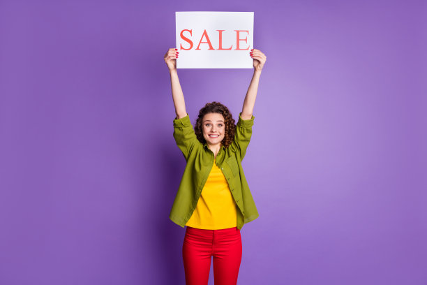 年轻快乐、兴奋、微笑、开朗、积极的女孩的照片，头顶上孤立在紫色的背景上，举着销售标书图片下载