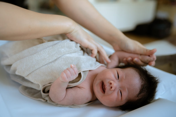 妈妈在一个小浴缸里给她的小女儿洗澡。图片下载