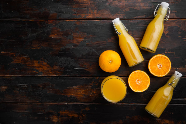 新鲜的橙汁，在旧的深色木桌的背景上，平躺俯视图，与文本复制空间图片下载