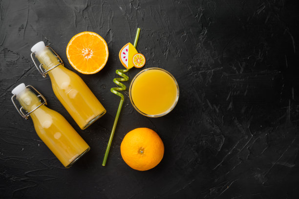 橙汁，在黑色深色的石桌背景上，俯视图平铺，有文字复制空间图片下载
