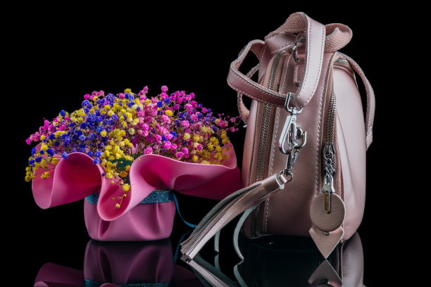一个女人的粉色包放在一束花的旁边图片下载