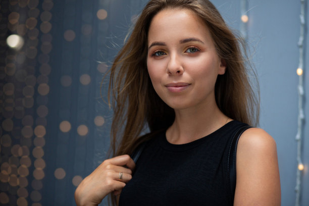 一个快乐的金发女人戴着花环靠在蓝色的墙上的街头肖像。空的空间图片下载