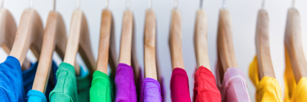 旗帜作物copyspace纹理的衣服架的文本。衣服挂在衣架在家庭衣柜或购物中心的商店销售概念。五彩缤纷的服装收藏。全景广告。图片下载