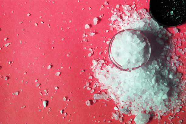 在明亮的背景上，海盐撒在一个罐子的顶部图片下载