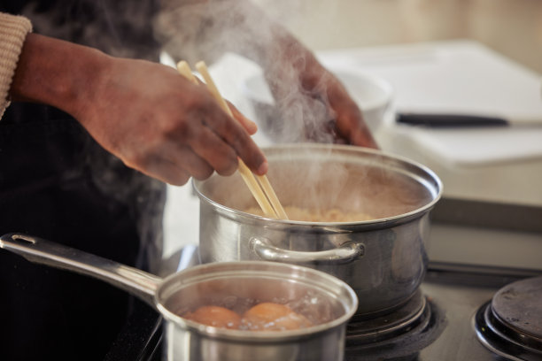 一名面目全非的男子在自家厨房的炉子上做饭图片下载