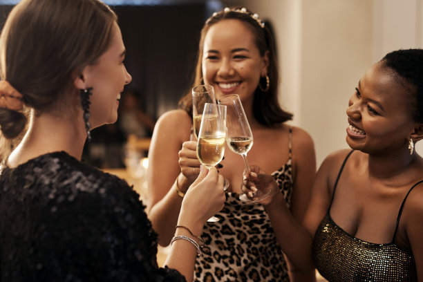 在新年晚宴上，一群不同的朋友站在一起，用香槟干杯图片下载