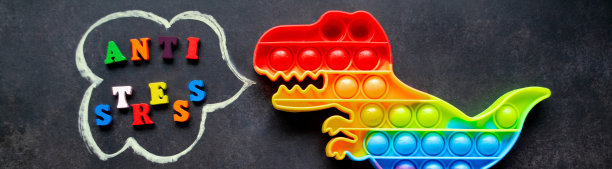 横幅与pop它的恐龙玩具彩虹颜色在黑色的背景上有多种颜色的字母和题词-抗压力在一个演讲泡泡图片下载