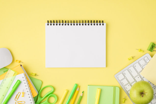上面的照片笔记本，钢笔，铅笔，毡尖，剪刀，尺子，回形针，苹果，电脑，鼠标和键盘孤立在黄色的背景上图片下载