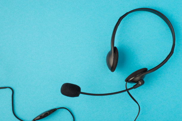 顶视图照片的黑色有线耳机与麦克风在孤立的蜡笔蓝色背景与空白图片下载