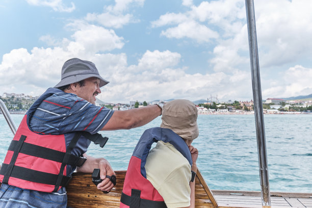 亚洲男孩和年长的男人，他的祖父，在海上的游船旅行。图片下载