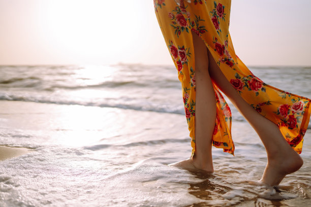 年轻女子享受美丽的日落，宁静的海洋自然在旅行假期。图片下载