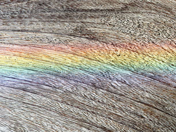 木桌上的彩虹光谱图像穿过一束带有背景的阳光。图片下载