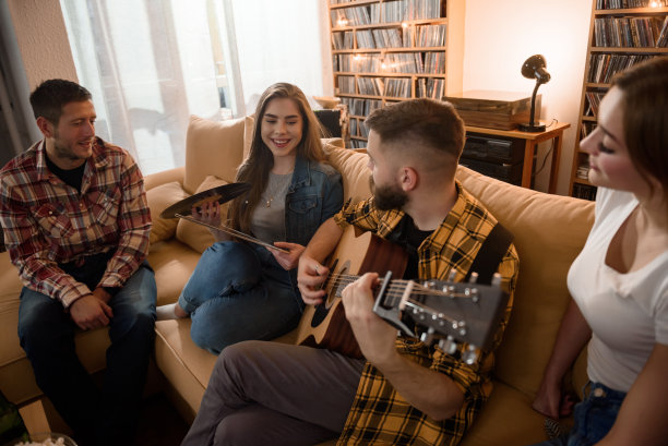 一群朋友在一个家庭聚会上弹吉他，欣赏音乐图片下载