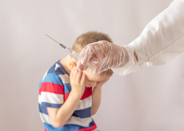 医生拿着注射器注射疫苗。男孩害怕。害怕打针图片下载