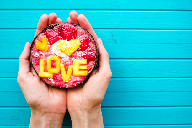 冰沙碗在女性手中的绿松石木制背景，复制空间。饮食观念，适当的营养和健康，俯视图图片下载