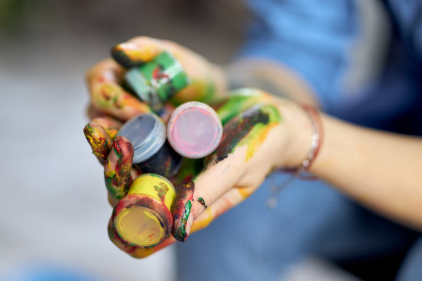 近距离拍摄的女性手拿着彩色丙烯酸颜料在罐子图片下载
