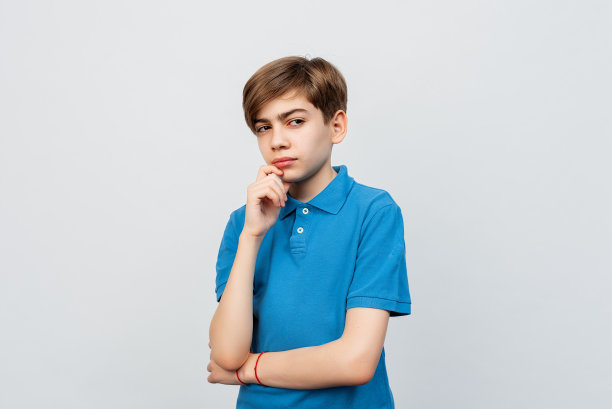 体贴的帅哥12-14岁牵着下巴摆出优柔寡断的姿势，看着旁边的拷贝空间图片下载