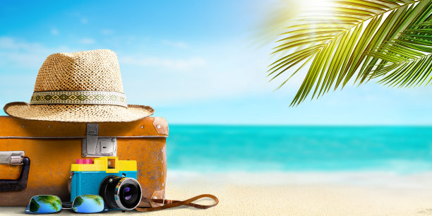 复古行李箱，复古胶片相机和草帽在海景背景图片下载