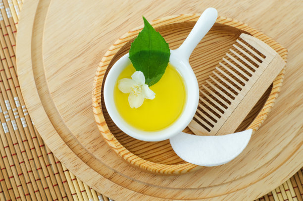 白色的小碗，里面有化妆(清洁)香油，棉眼罩，木发刷和白色的茉莉花。天然护肤护发，自制水疗美容配方。俯视图，复制空间。图片下载