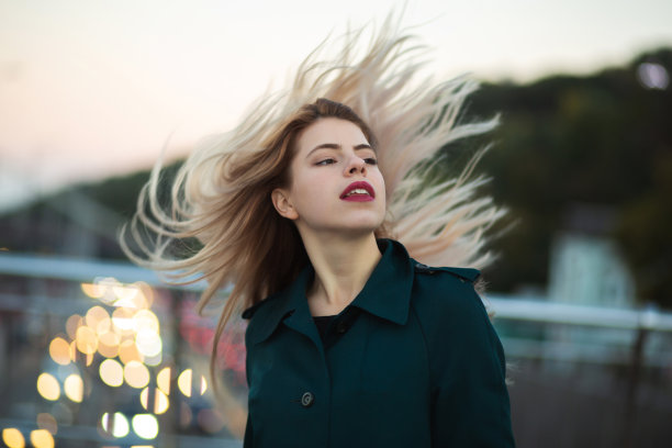 优雅的年轻女子与红唇与风的头发摆姿势。空间的文本图片下载