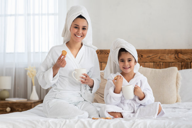 可爱的母女在床上喝茶图片下载