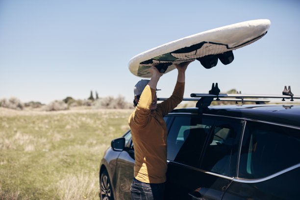 风帆和露营者从汽车的车顶行李架打包和拆包。图片下载