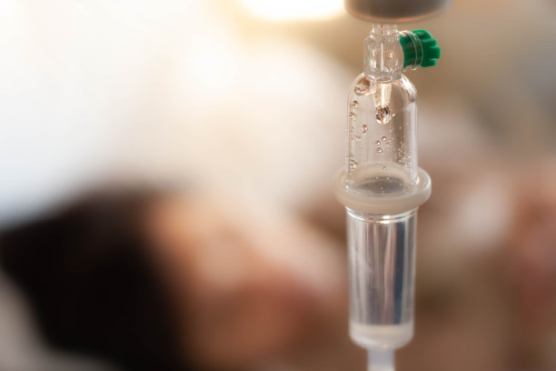 设置维生素静脉滴注生理盐水与模糊女子躺在病床上病房背景。医学观念治疗、急诊、注射、输液、护理、化疗观念。选择性的焦点和自由空间的文本图片下载
