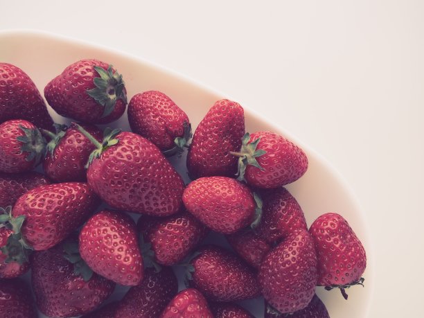 盘子上的草莓，白色背景。白色的菜肴和美味的红色大花园草莓。健康的食物，维生素和素食。有食物的静物。副本的空间。平躺图片下载