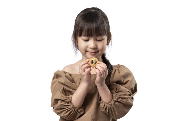 快乐的女孩吃全谷物饼干的肖像在孤立的白色背景上图片下载