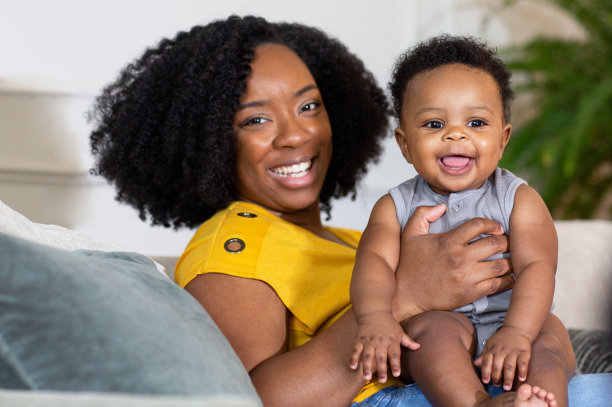 快乐的妈妈在家里笑着和儿子玩。图片下载