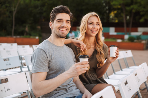 一对快乐可爱的年轻夫妇坐在椅子上图片下载