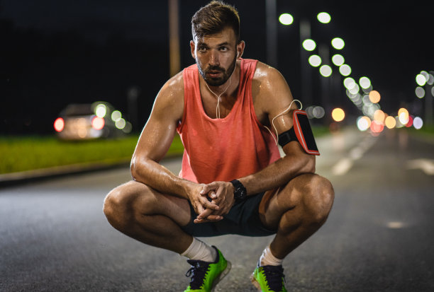男性跑步者在城市晚上锻炼后休息。图片下载
