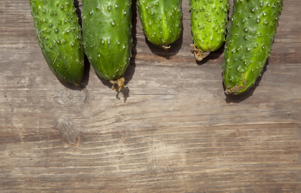 新鲜的农场有机黄瓜在木制的背景。健康饮食不含转基因的有机蔬菜，100%纯素食减肥食谱木质背景图片下载