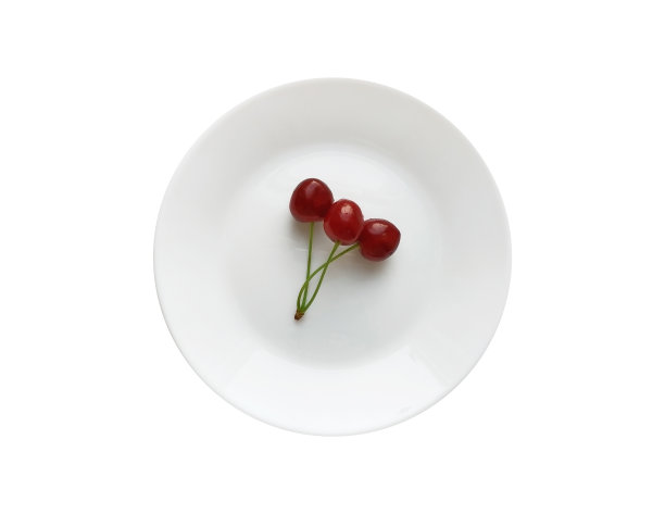 一串樱桃放在白色的圆盘子上，孤立在白色的背景上。俯视图图片下载