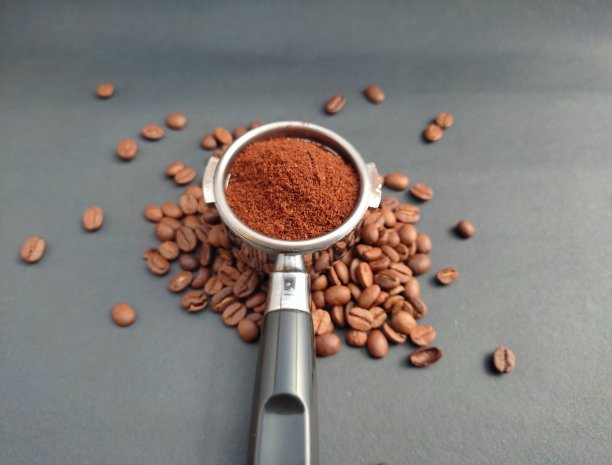 磨碎的咖啡在porta滤镜支架上的黑色背景图片下载