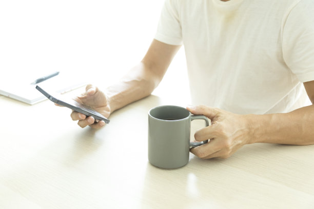 年轻男子在家里使用智能手机的特写。图片下载