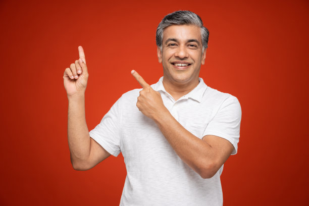 肖像的成熟男子站在孤立的红色背景:股票照片图片下载