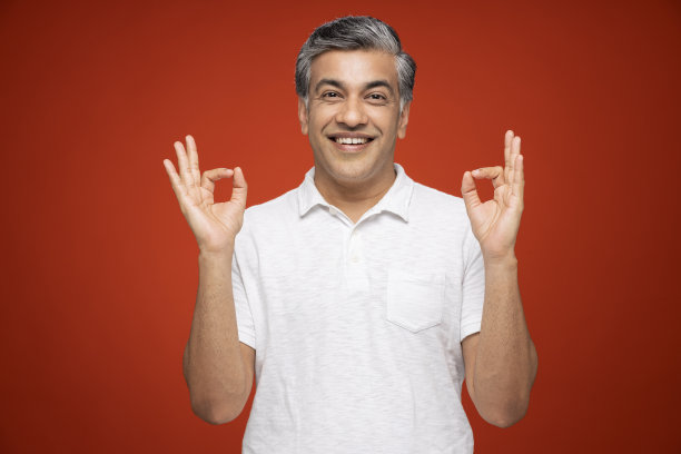 肖像的成熟男子站在孤立的红色背景:股票照片图片下载