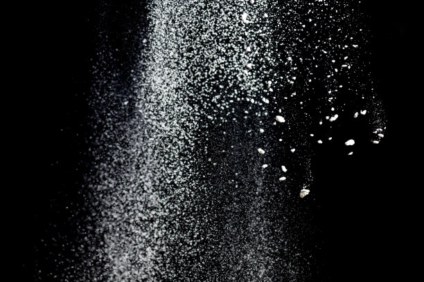 白色粉末爆炸。白色粉末飞溅孤立在黑色背景上。面粉筛在一个黑暗的背景。爆炸性的白色粉末图片下载