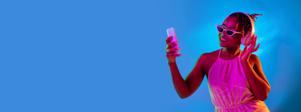 半长肖像年轻美丽的女孩孤立在蓝色工作室背景霓虹灯。摩天观景轮图片下载