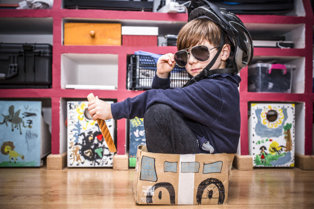 可爱的小男孩在玩漆成汽车的纸板箱图片下载