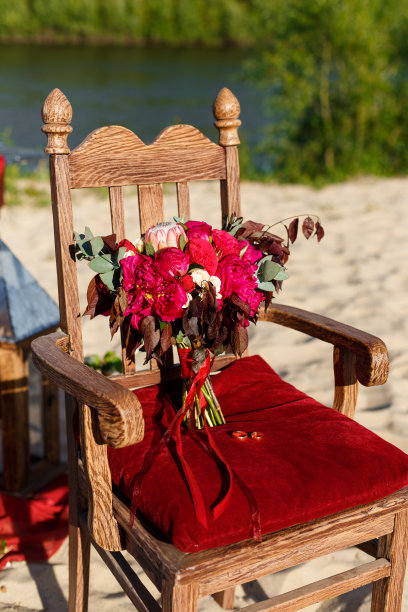 昂贵，时尚的婚礼花束玫瑰和牡丹在马萨拉和红色站在木椅上。婚礼细节和装饰鲜花，夏天，户外图片下载