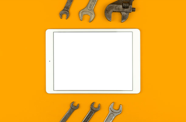 建筑修复模型概念，平板与空白的白色屏幕在桌子上与服务工具和设备，黄色背景，俯视图，平面铺设和复制空间照片图片下载