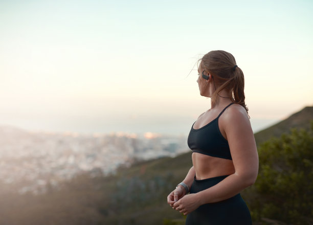 这张照片拍摄的是一名年轻女子在爬山后看风景图片下载