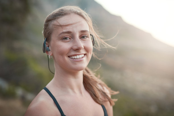一张年轻女子戴着耳机在户外跑步的照片图片下载