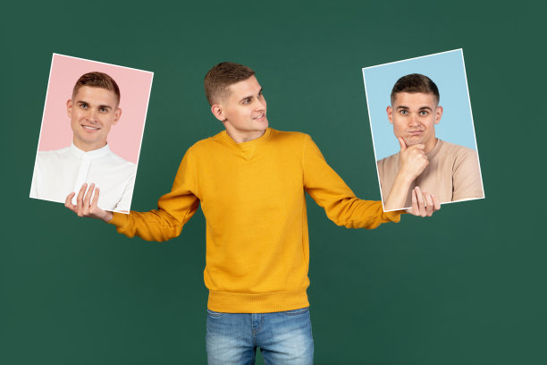 一个年轻的白人男子举着他的照片孤立在绿色的工作室背景与广告的copyspace。人类情感的概念图片下载