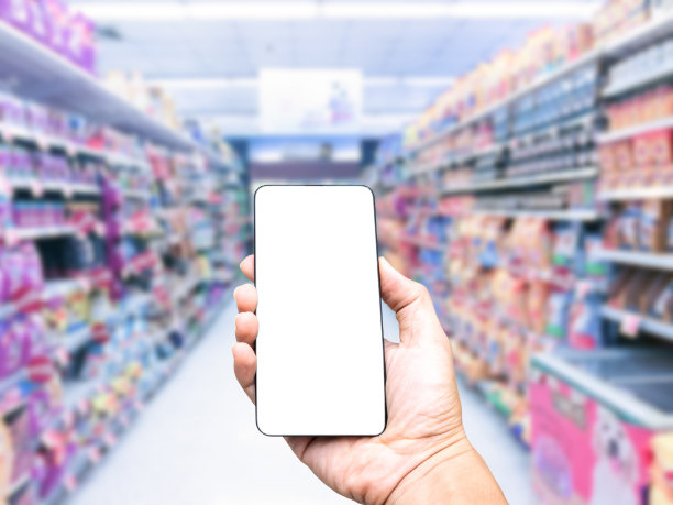 手持智能手机的白色屏幕模糊购物中心的背景图片下载