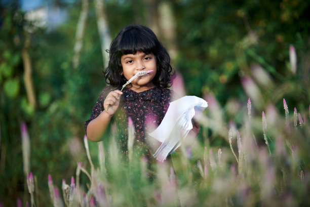 一个亚洲女学生在自然公园看书和独自玩耍图片下载