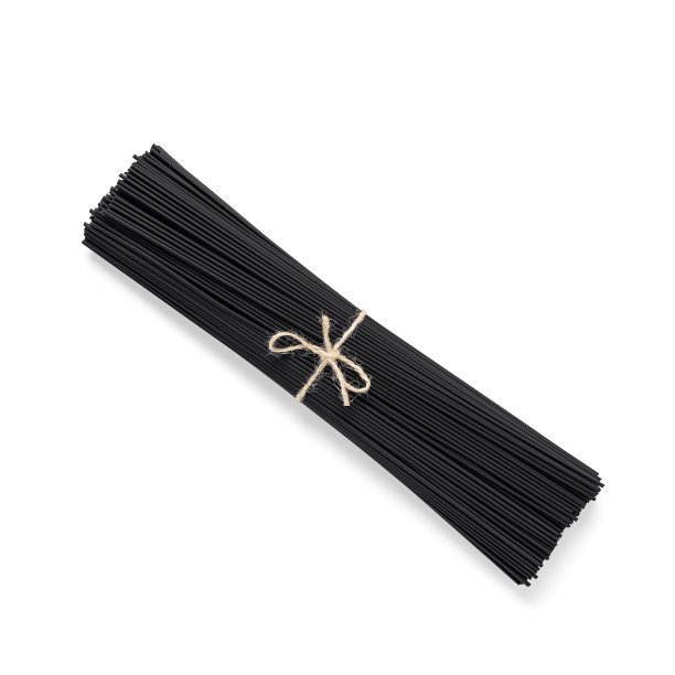 生的黑色意大利面条串孤立的白色背景。干黑通心粉。俯视图，平放。图片下载